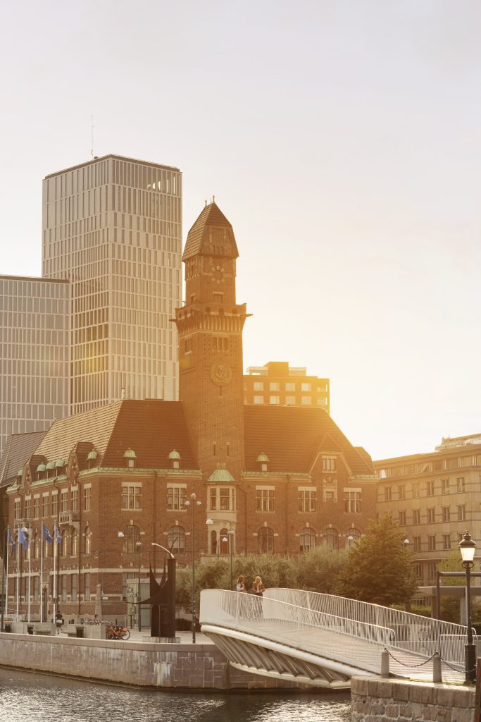Two female friends walking on bridge in city